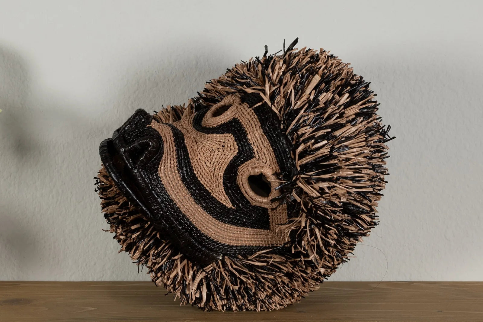 Handwoven brown Poodle dog mask featuring intricate patterns and natural fibers, adding unique decor to any space.