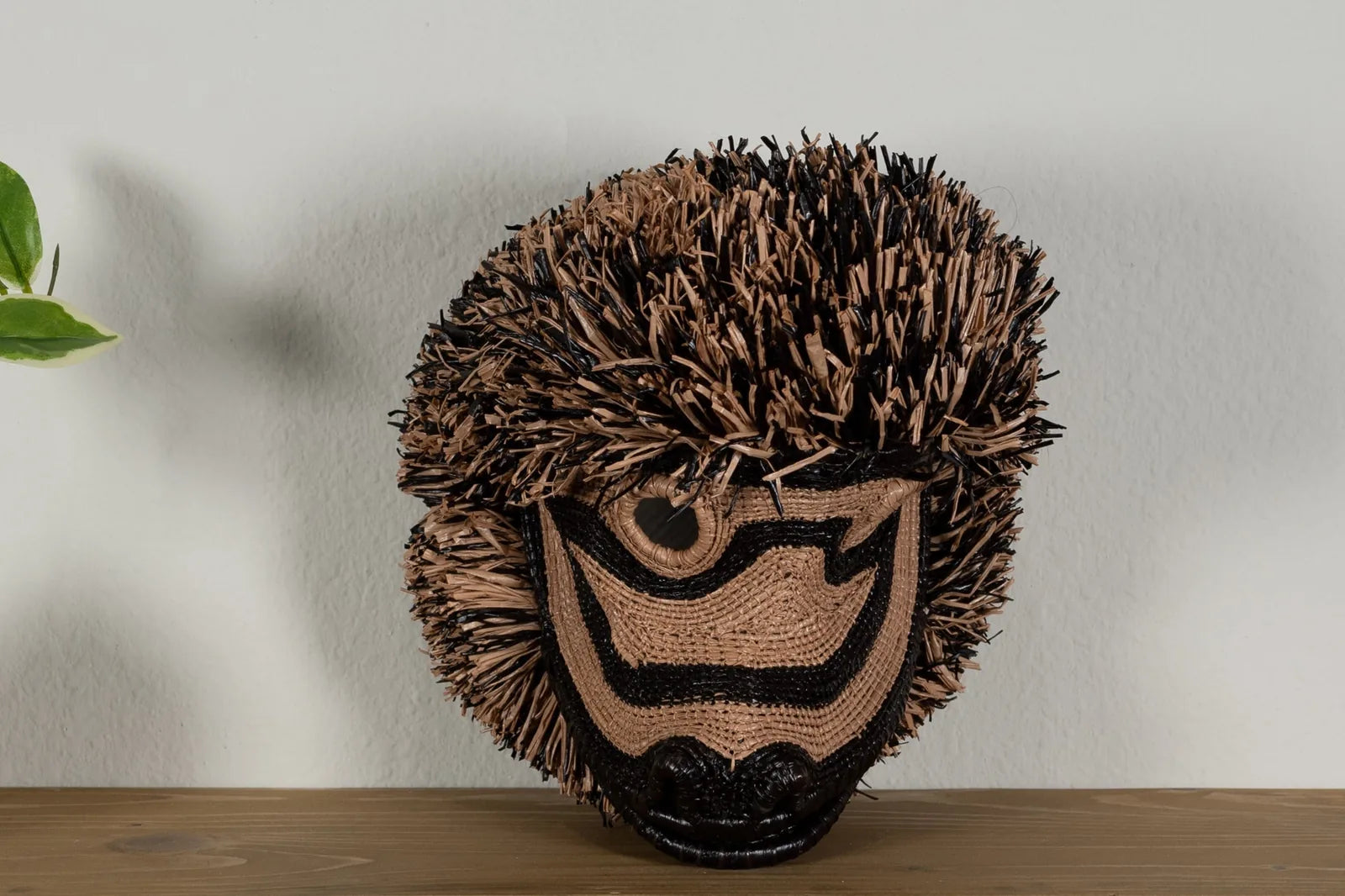 Handwoven brown poodle dog mask featuring intricate patterns and natural fibers, perfect for unique wall decor.