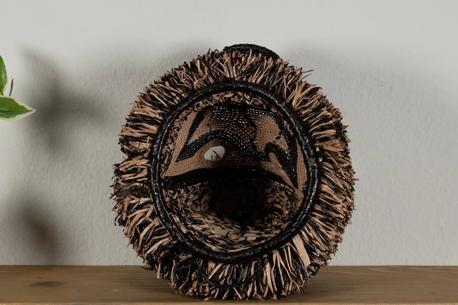 Handwoven brown poodle mask featuring intricate patterns and natural fibers, ideal for unique wall decor.