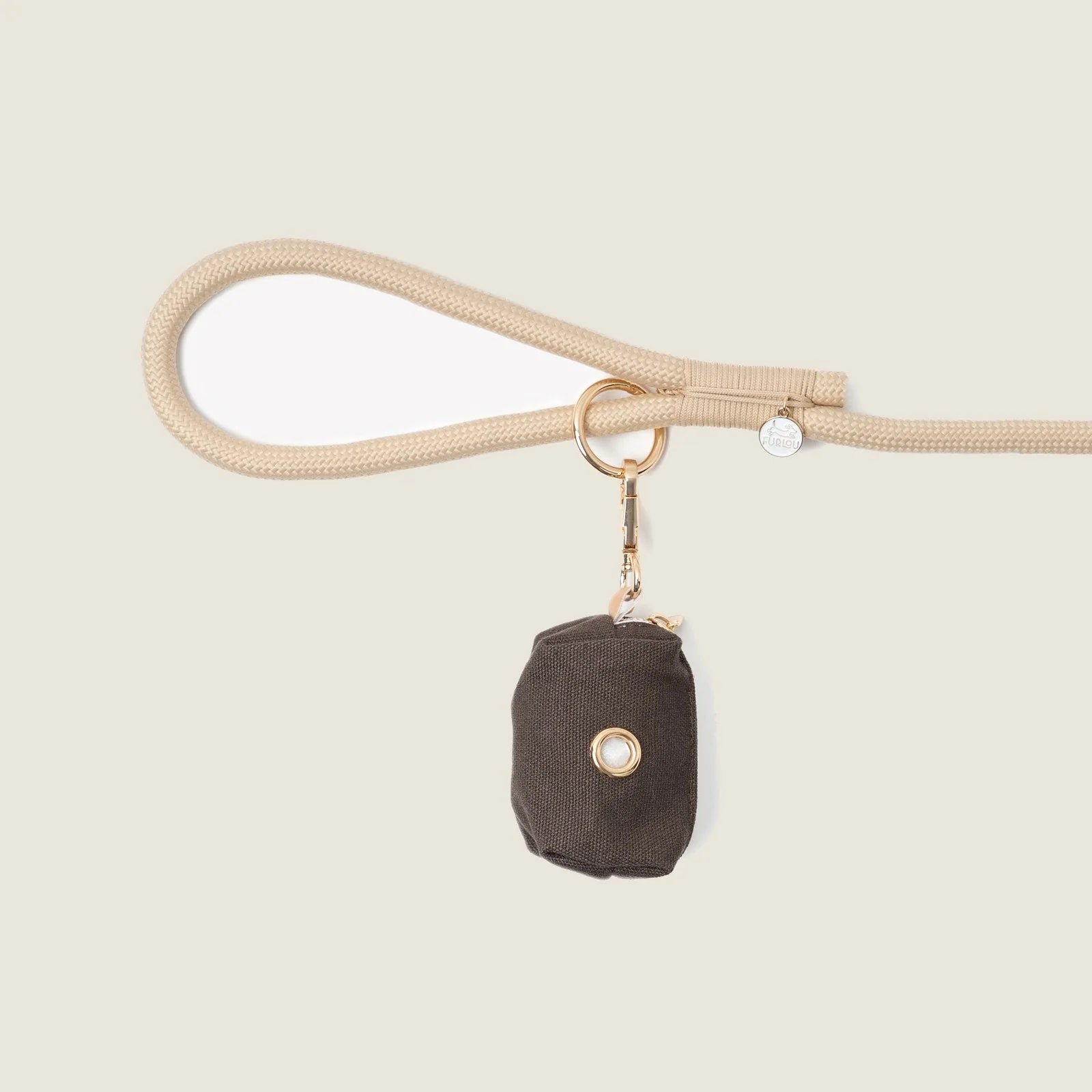 Brown poop bag holder by FURLOU clipped to a beige leash, featuring a simple design and gold hardware.