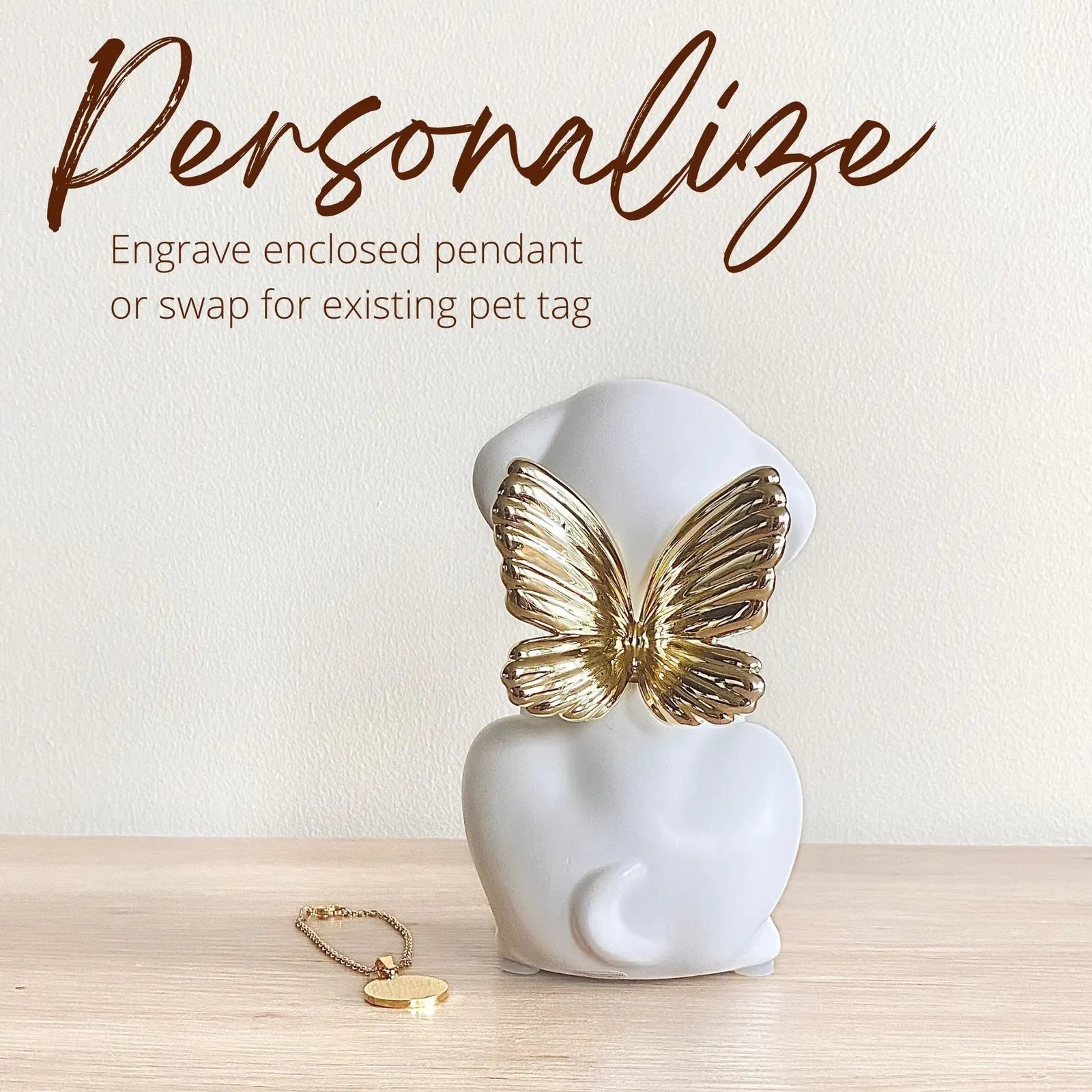 Elegant white dog urn with gold butterfly wings, featuring a pendant for personalization, perfect for honoring beloved pets.