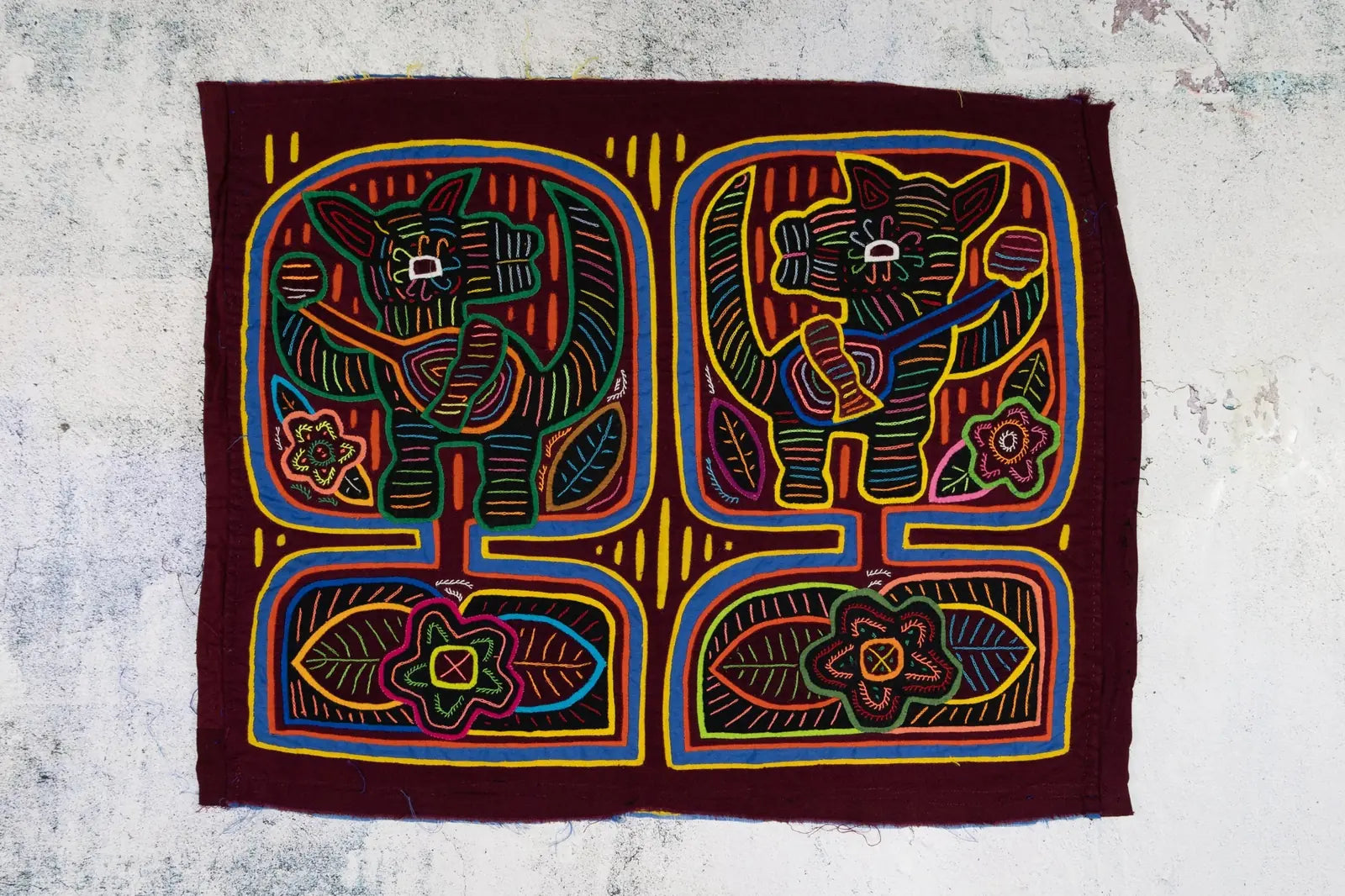 Hand-stitched burgundy tapestry featuring colorful banjo-playing puppy designs and floral patterns, showcasing vibrant rev...