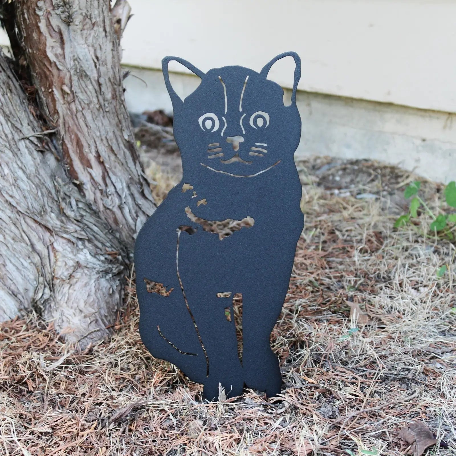 Black metal silhouette of a Burmese dog resting against a tree, showcasing intricate cut-out details and sturdy design.