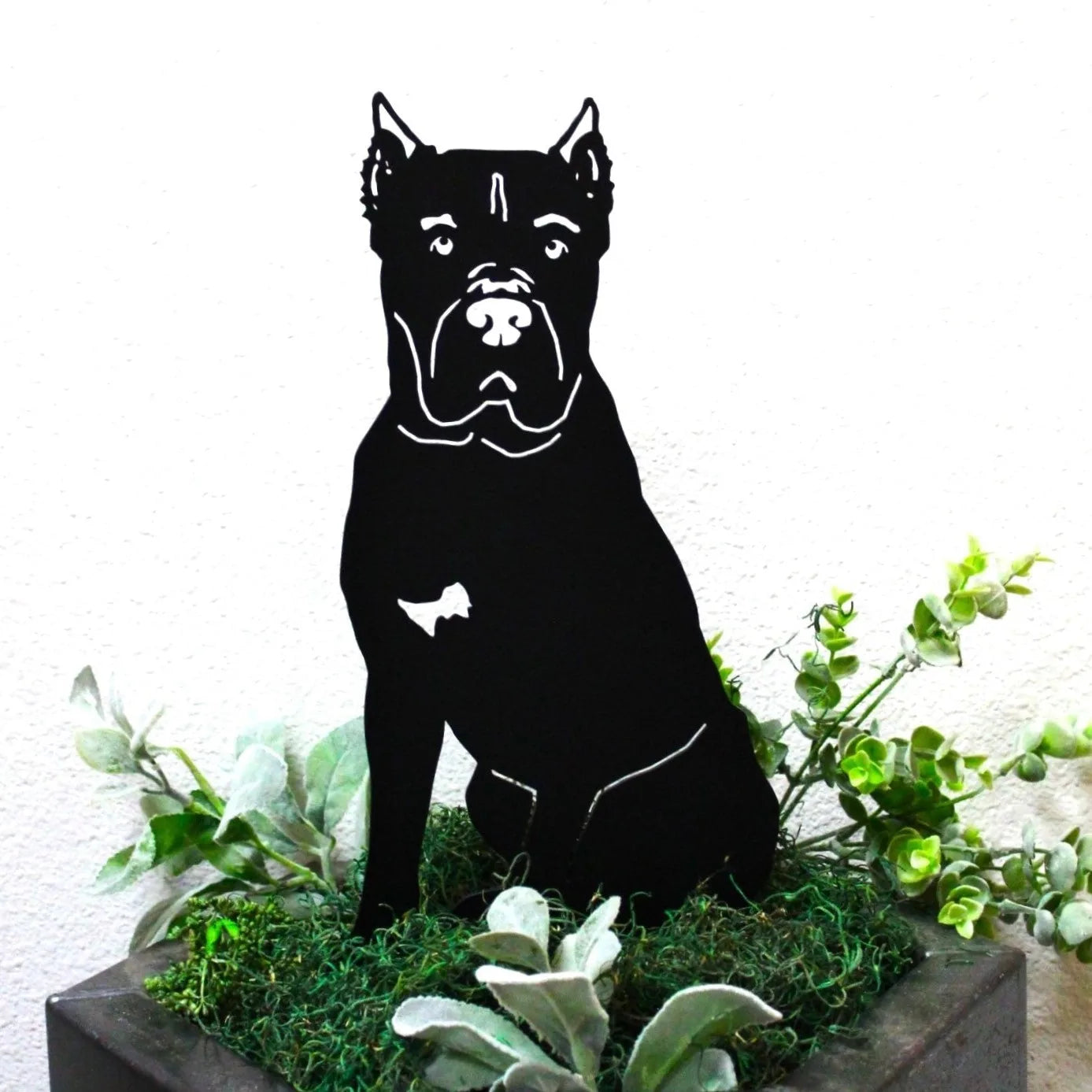 Cane Corso metal silhouette in matte black, surrounded by greenery, perfect for outdoor decor.