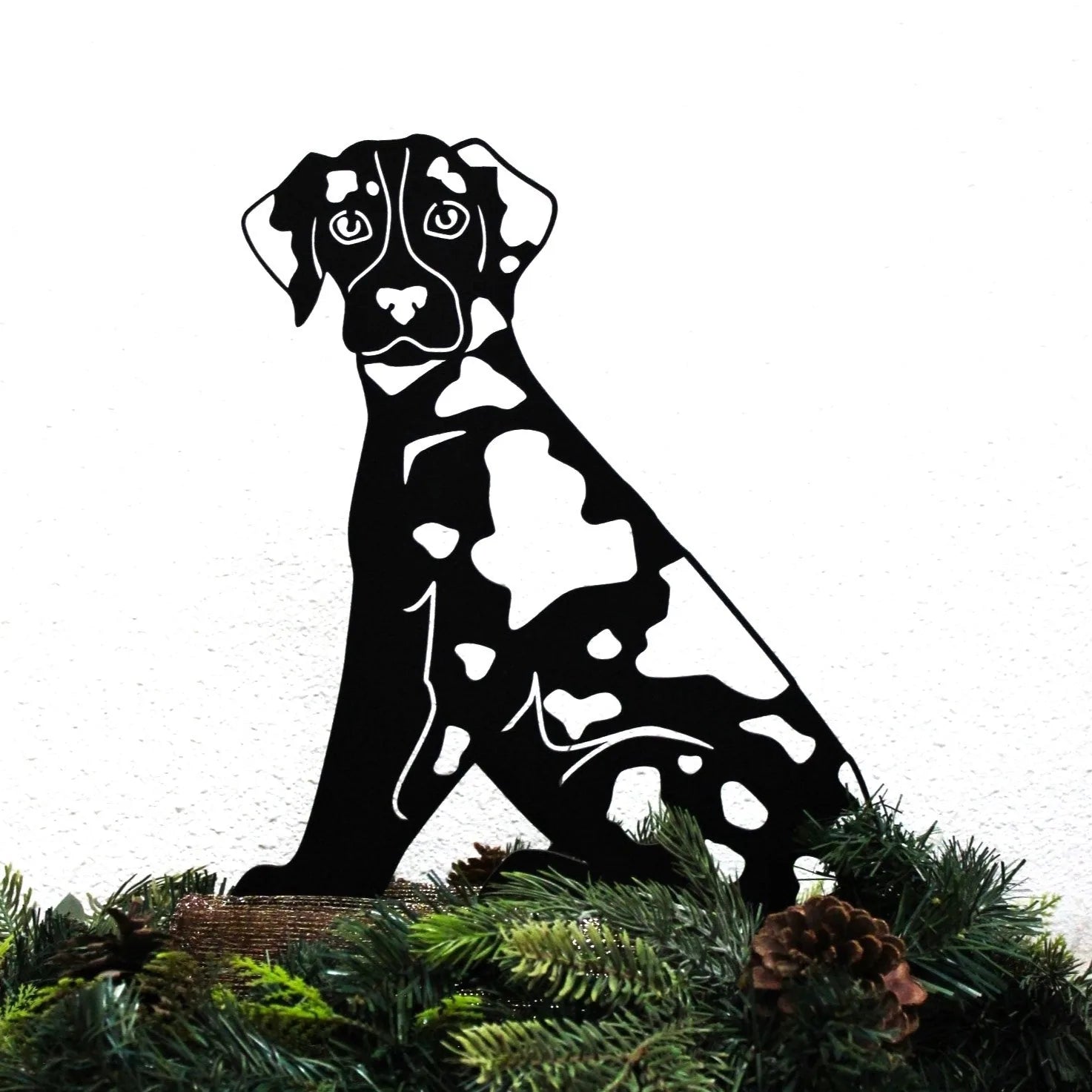Black metal silhouette of a Catahoula Leopard Dog, featuring distinct white markings, set against a white background.