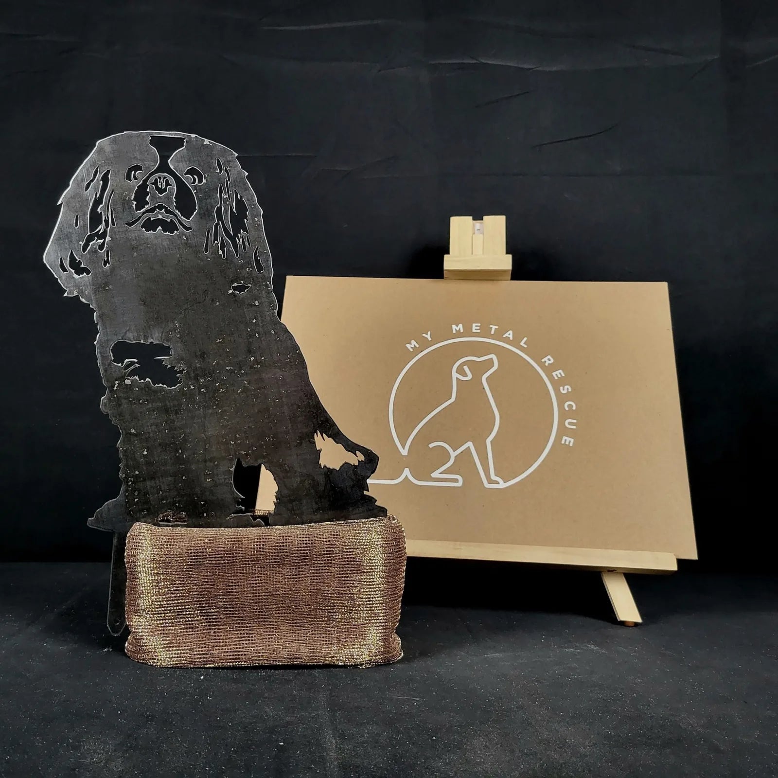 Cavalier King Charles Spaniel silhouette in Corten steel, showcased on a decorative base, against a neutral backdrop.