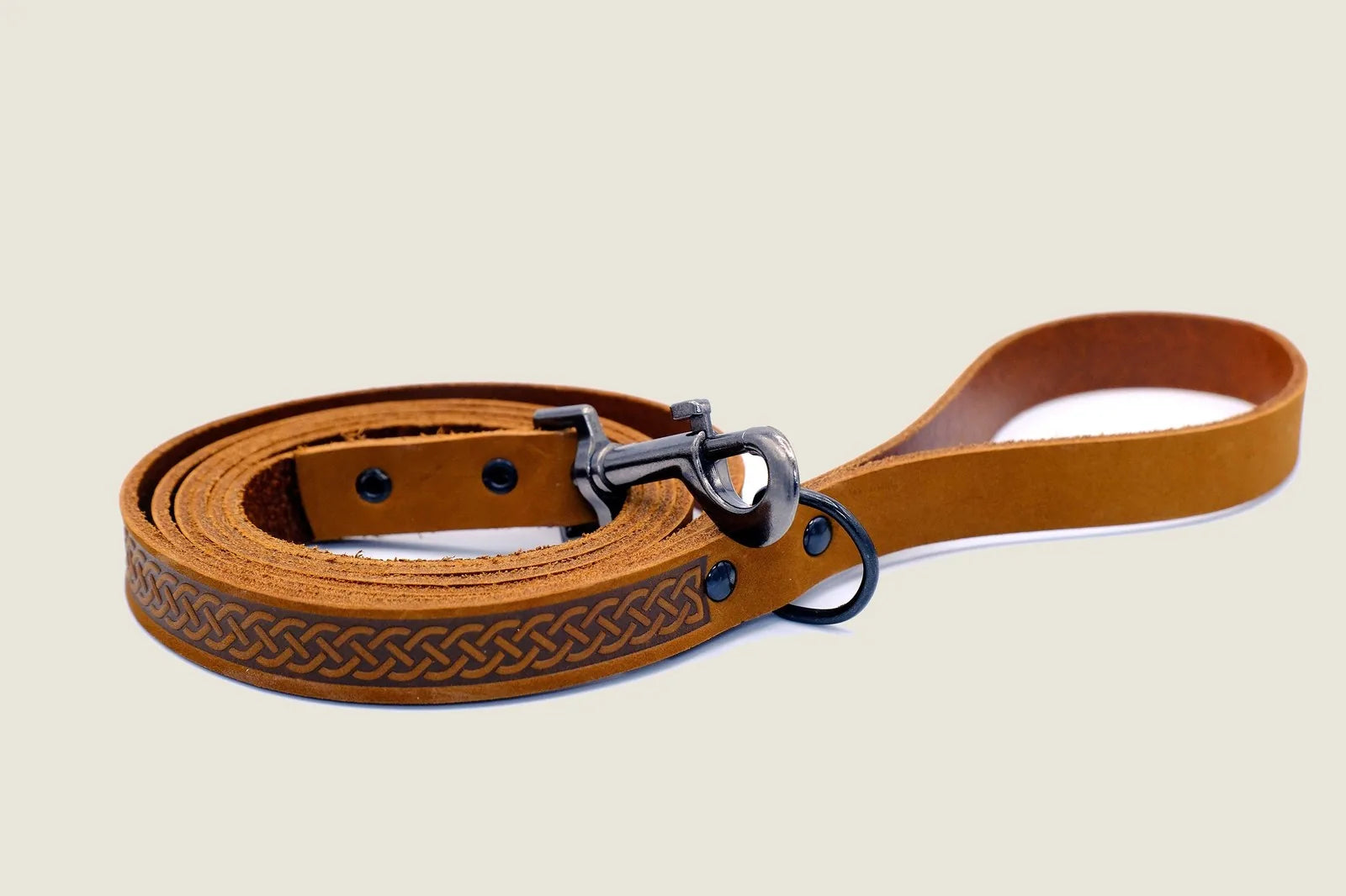 Tan leather dog leash featuring a braided design, durable metal clasp, and sturdy construction for walks and adventures.