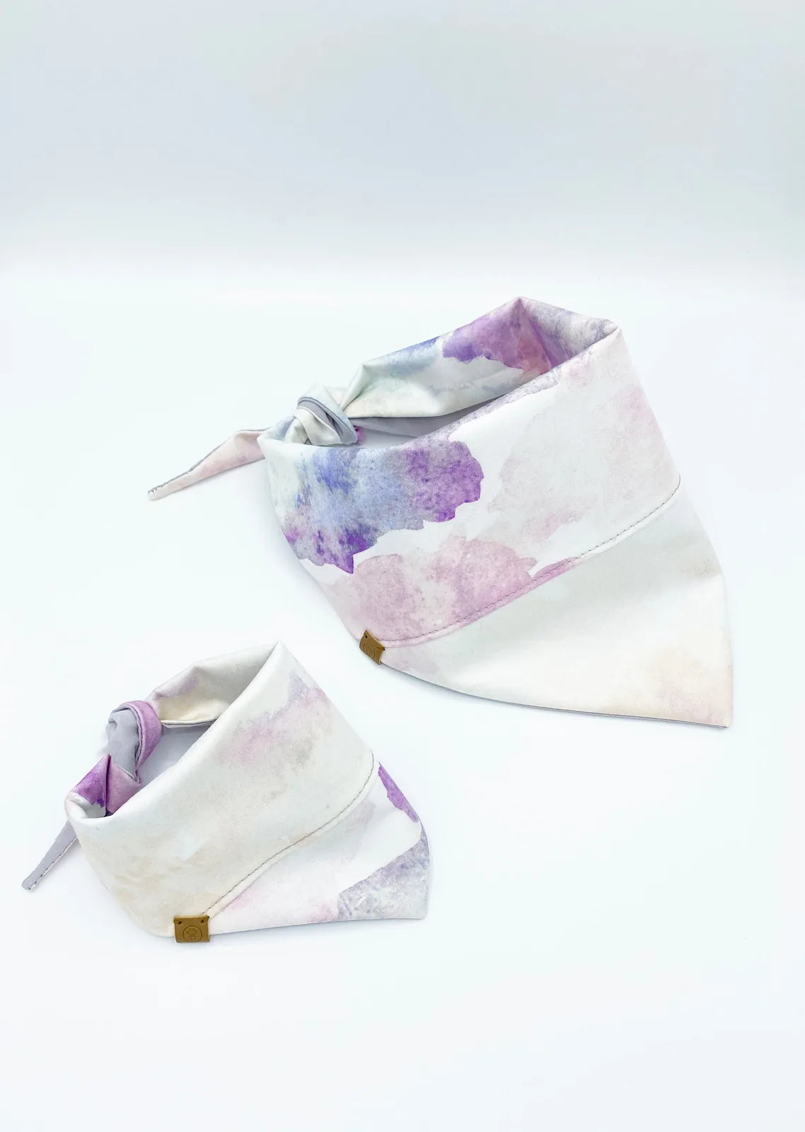 Reversible pet bandanas in pink tie-dye and solid lilac, crafted from soft 100% cotton for stylish pet accessories.