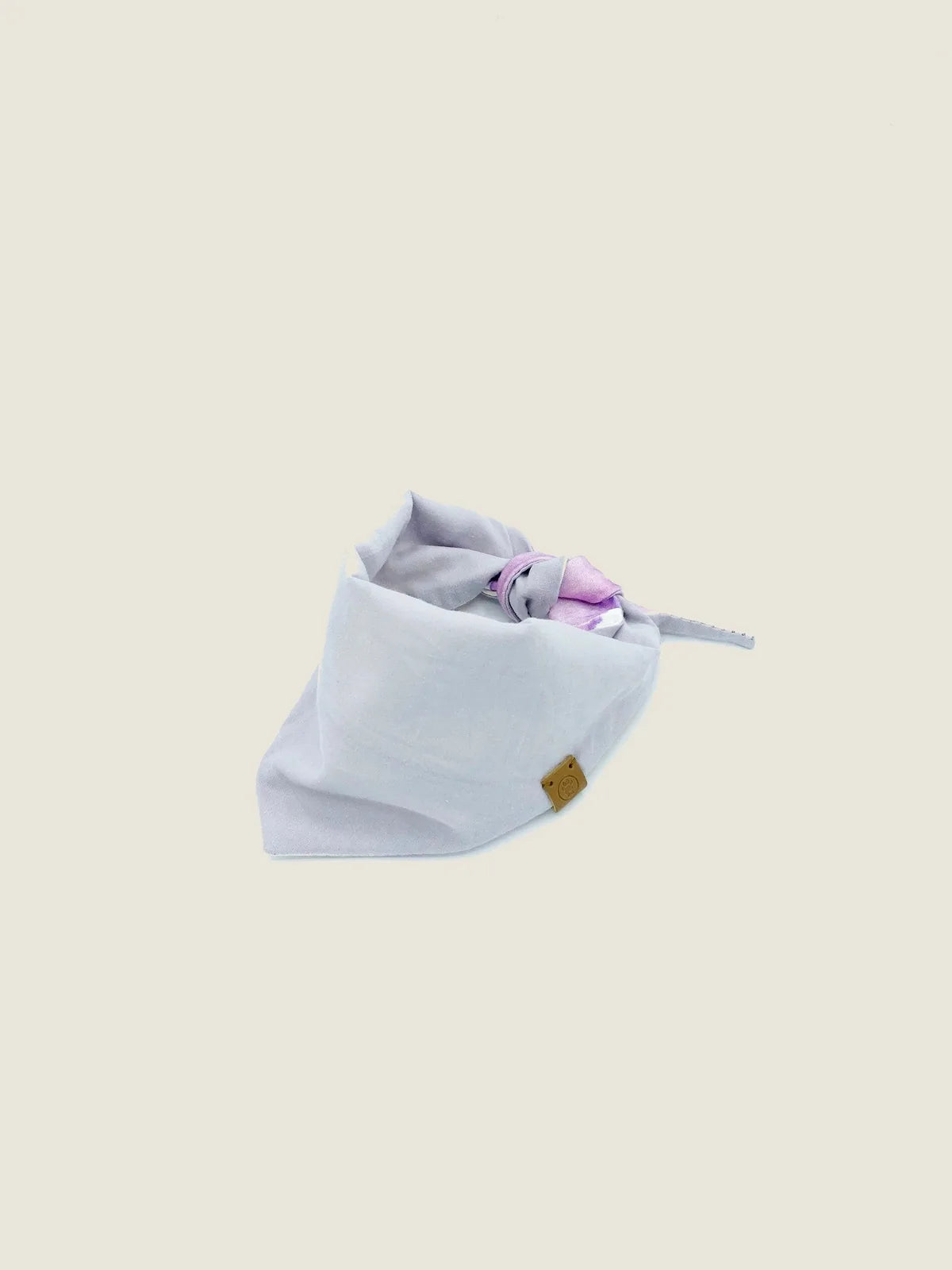 Reversible pet bandana in lilac poplin with pink tie-dye, made from soft, durable cotton, featuring a branded tag.