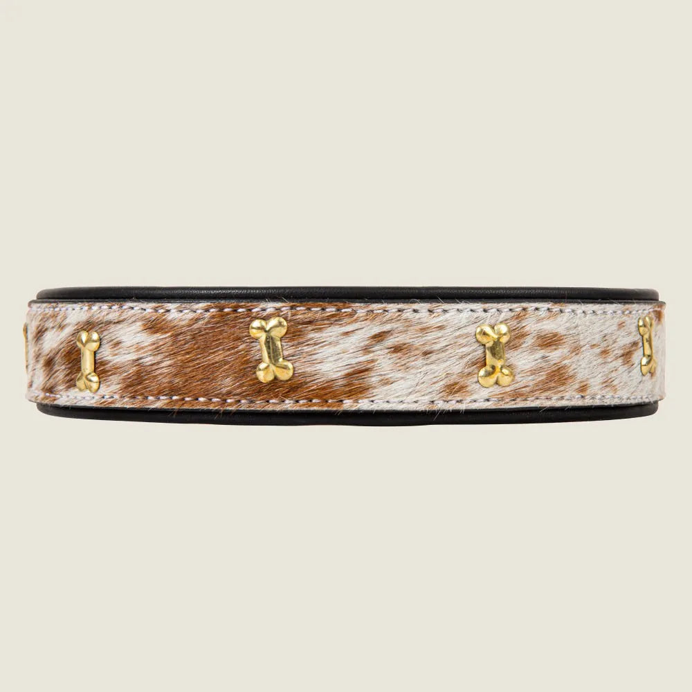 Brown and white hair-on hide dog collar featuring gold-tone bone accents, 1 inch wide and adjustable for neck sizes 16 to...