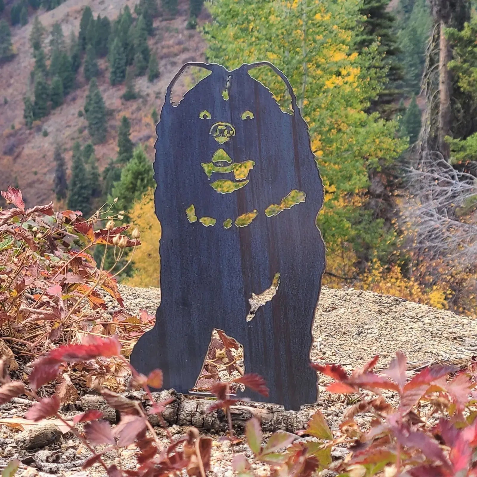 Chow Chow silhouette in weathered corten steel, surrounded by autumn foliage, ideal for outdoor dog decor.