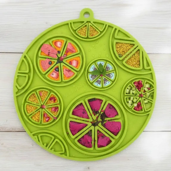 Citrus design lick mat in lime green with textured sections for treats, featuring suction cups for stability.