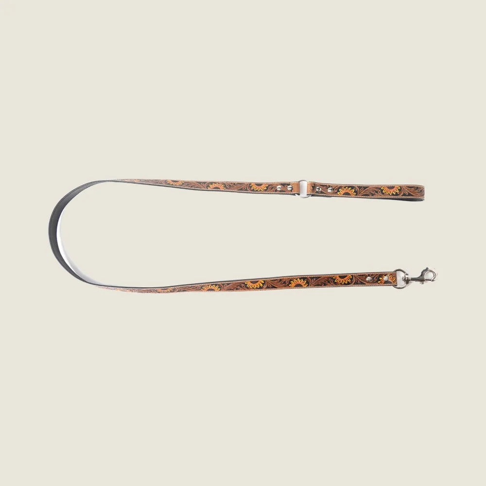 Light brown hand-tooled leather dog leash with floral embossing and metallic accents, designed for stylish dog walking.