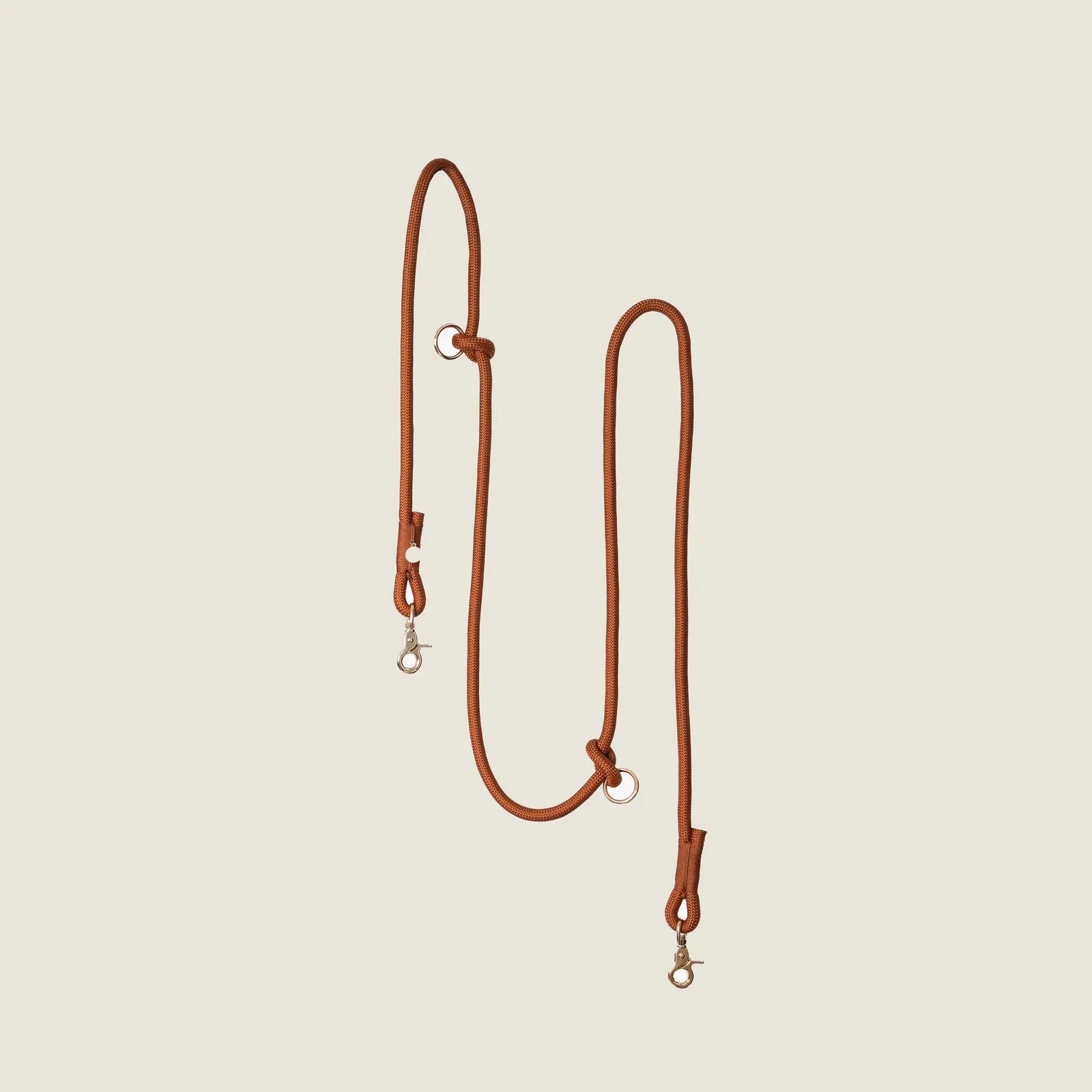 Hands-free braided leash in a warm clay color with silver clips and adjustability for optimal dog walking convenience.