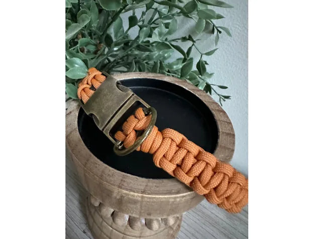 Handmade Cobra Braid dog collar in orange paracord, featuring a side release buckle and sturdy D-ring for leash attachment.