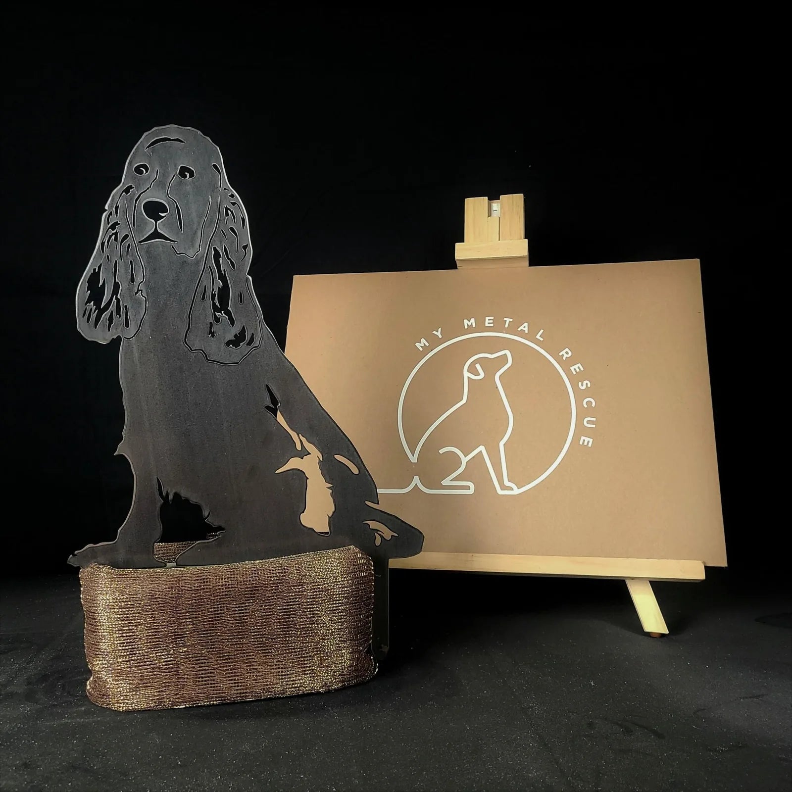 Cocker Spaniel silhouette in black metal, styled as outdoor decor, displayed beside a My Metal Rescue sign.