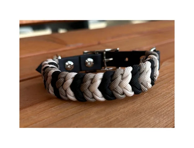 Handmade dog collar featuring a hand-braided design in black, tan, and cream, with sturdy metal hardware.