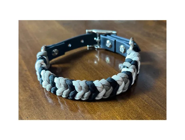 Hand-braided dog collar in black, tan, and cream, featuring durable nylon paracord and nickel-plated hardware.