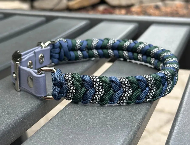 Handmade braided dog collar in navy blue, emerald green, and silver diamond pattern, crafted from durable nylon paracord.