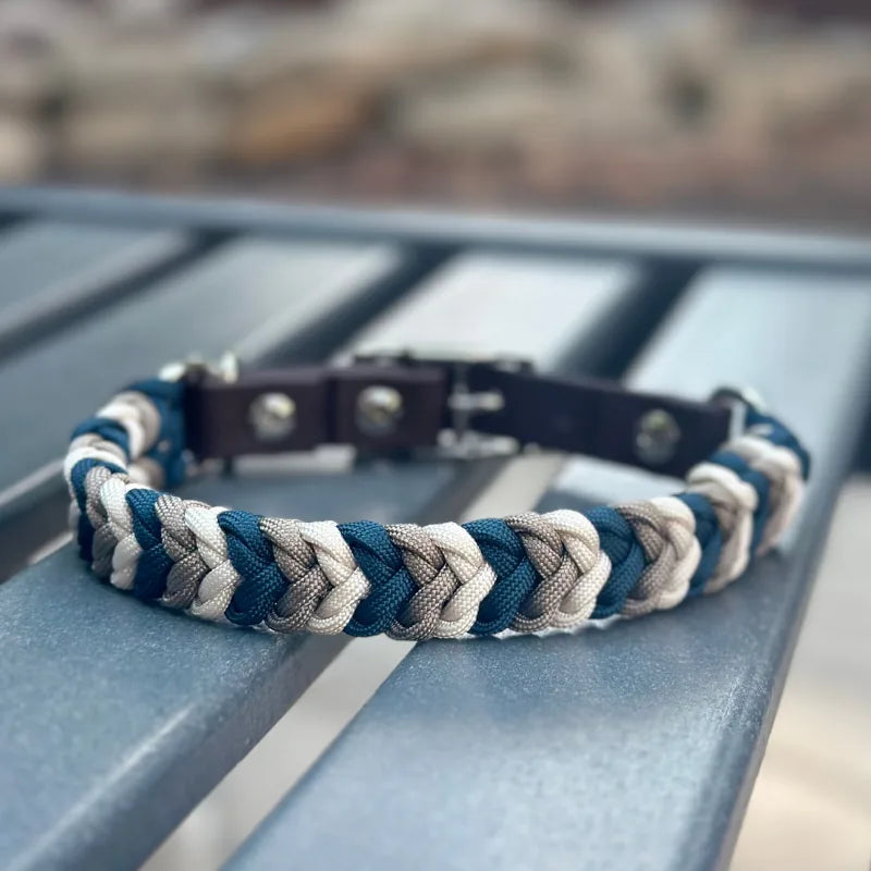 Hand-braided dog collar featuring navy, tan, and cream nylon paracord with a dark brown adjustable strap.