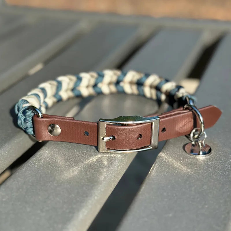 Hand-braided dog collar in navy, tan, and cream with a dark brown strap and nickel-plated buckle.