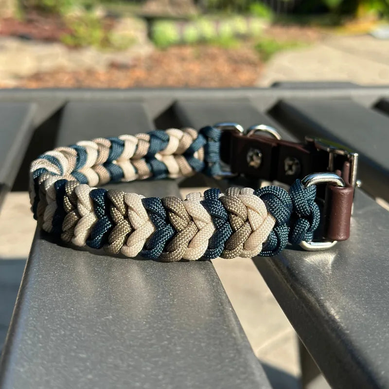 Hand-braided dog collar in navy, tan, and cream with a dark brown adjustable strap and nickel plated buckle.