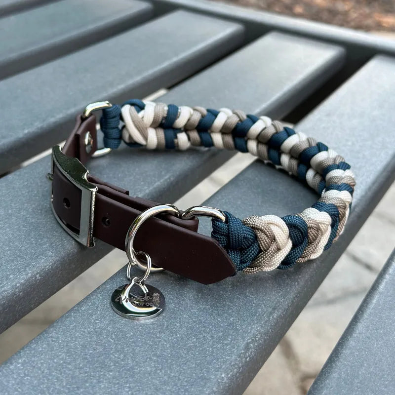 Hand-braided dog collar in navy, tan, and cream with a dark brown adjustable strap and nickel-plated buckle.