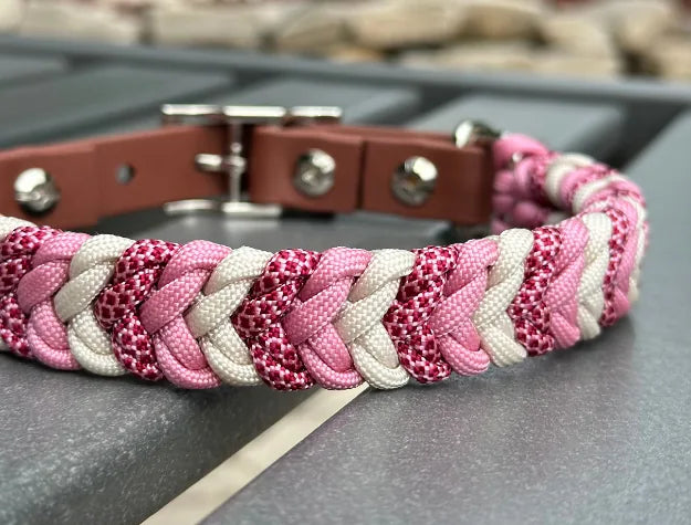 Hand-braided dog collar in pink, cream, and red diamond pattern with a medium brown adjustable strap and nickel buckle.
