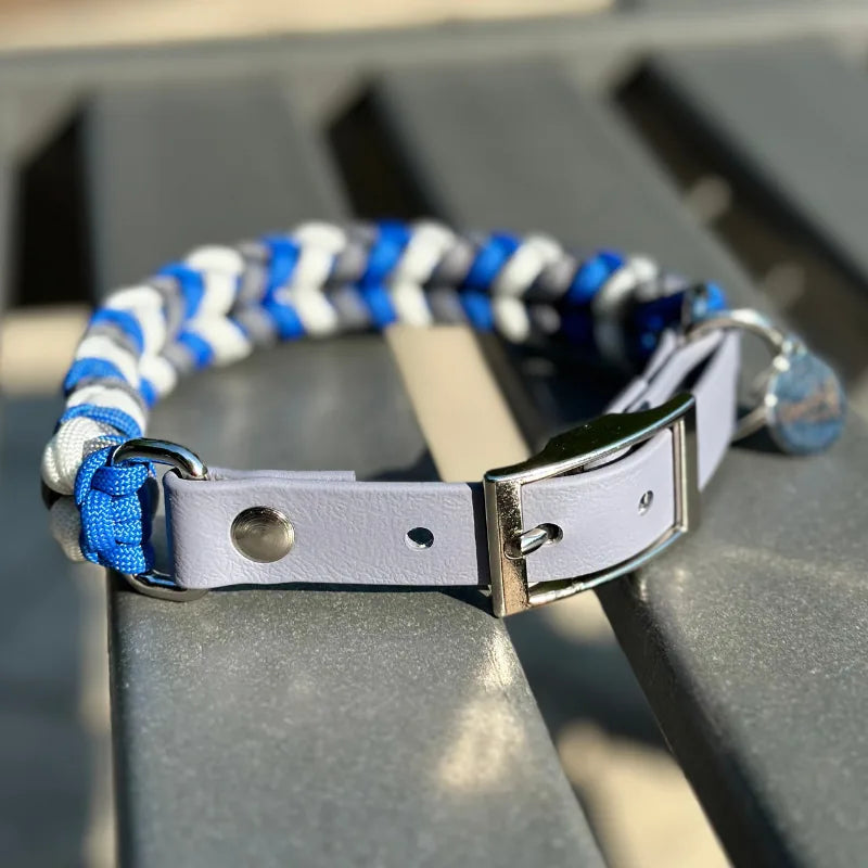Handmade dog collar featuring a hand-braided design in royal blue, graphite, and white with a gray adjustable strap.