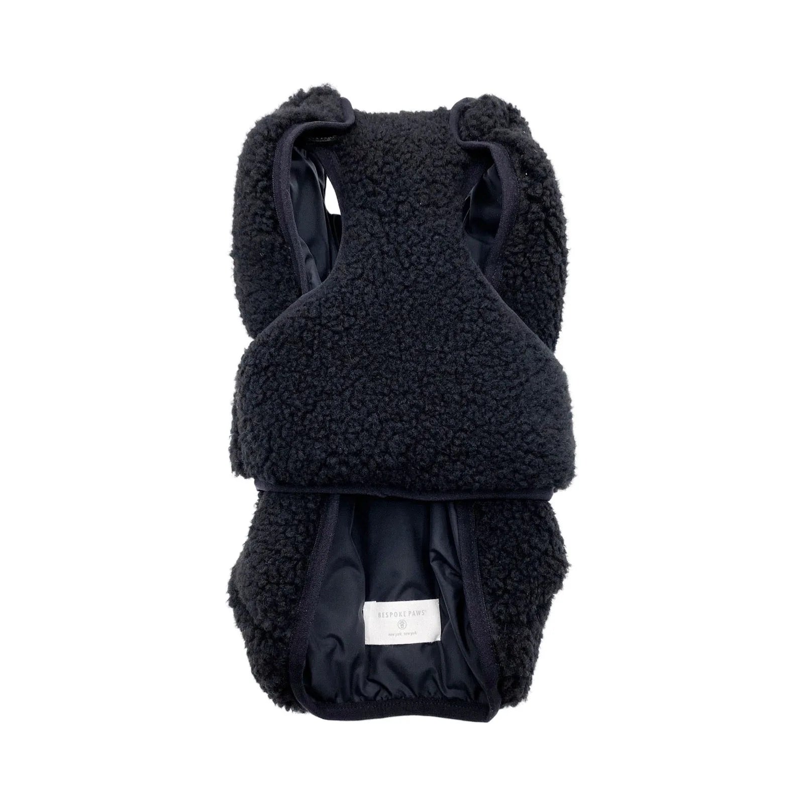 Black faux shearling dog vest by BESPOKE PAWS featuring a cozy design and soft inner lining. Reversible for versatile style.