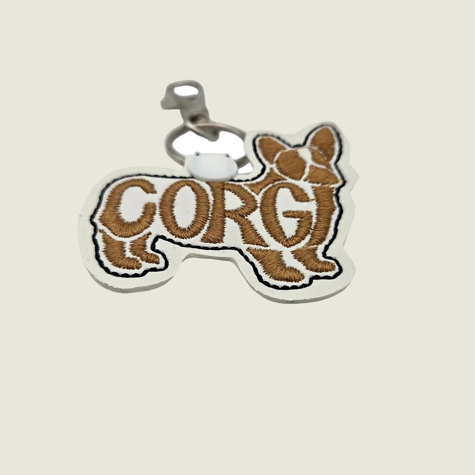 Embroidered keychain featuring a Pembroke Welsh Corgi silhouette with "CORGI" stitched in brown and white on faux leather.