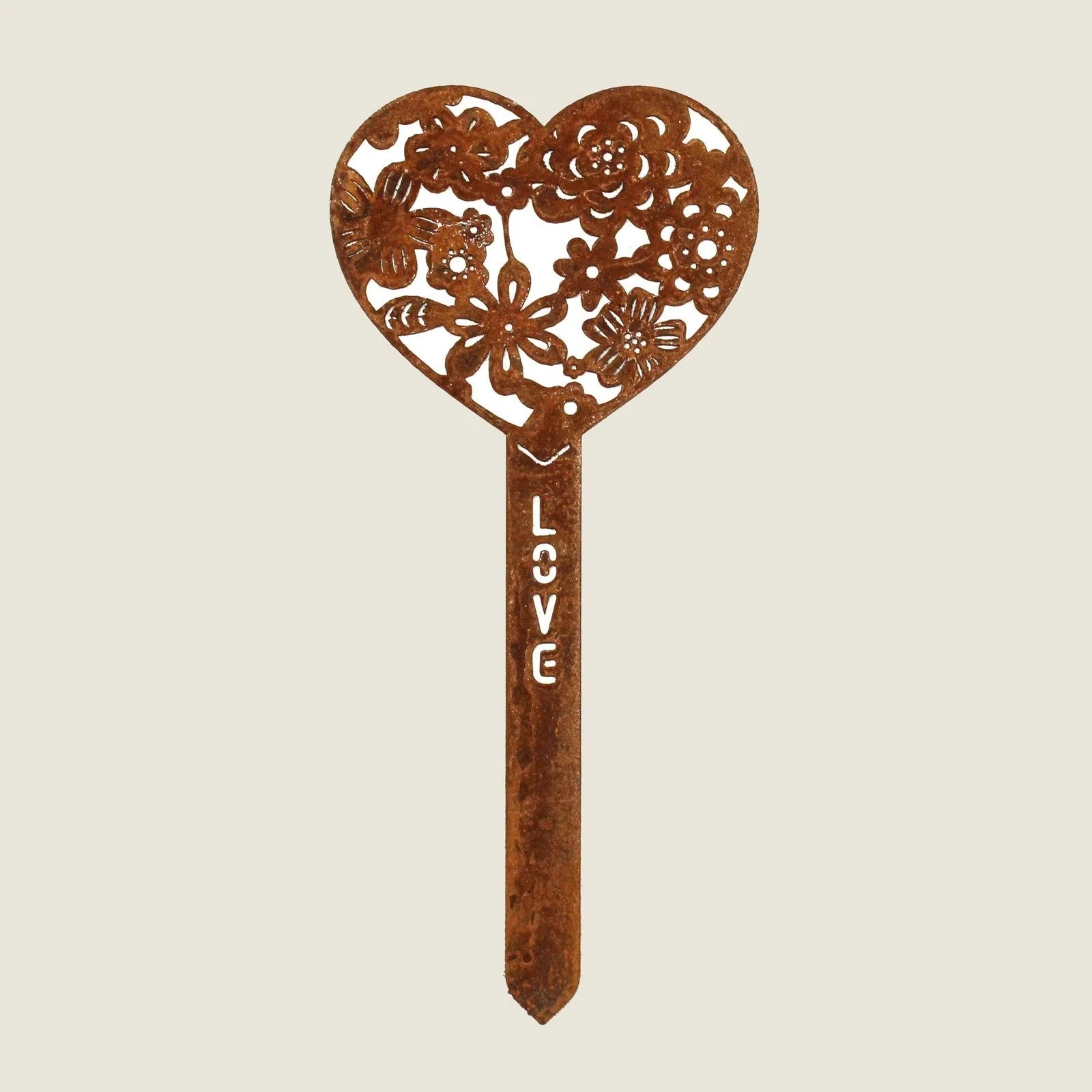 Heart-shaped Corten steel garden stake with intricate floral design and the word "LOVE" engraved, rusted finish.