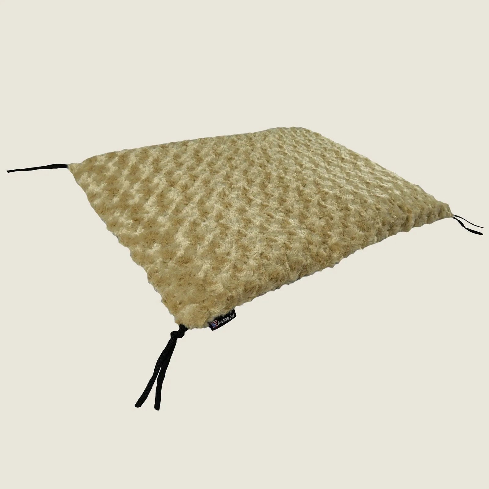 Soft camel-colored Furvana™ crate pad with textured Minky Fleece, featuring corner ties for secure placement.