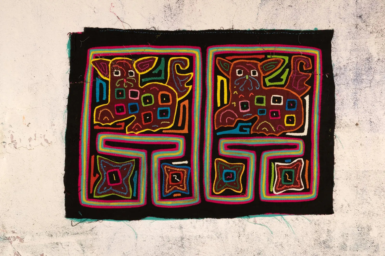 Hand-stitched decorative tapestry featuring a colorful puppy design in vibrant hues, showcasing traditional Guna textile art.