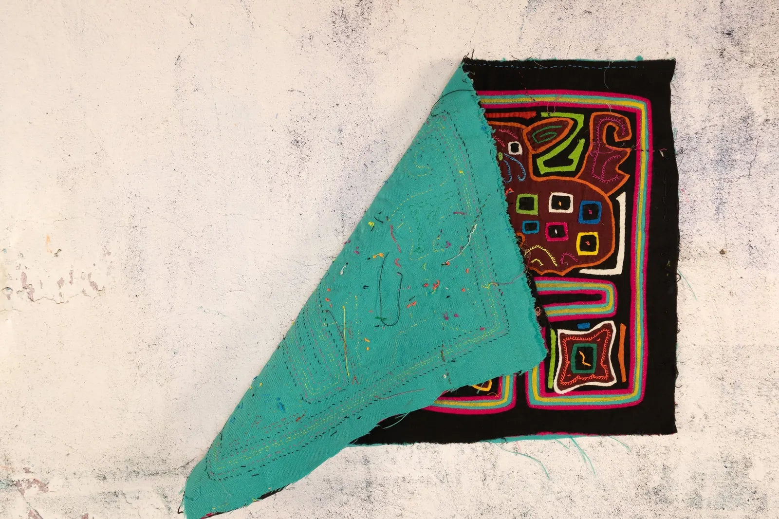 Hand-stitched tapestry featuring a colorful puppy design in brown and vibrant hues, showcasing Guna artisan craftsmanship.