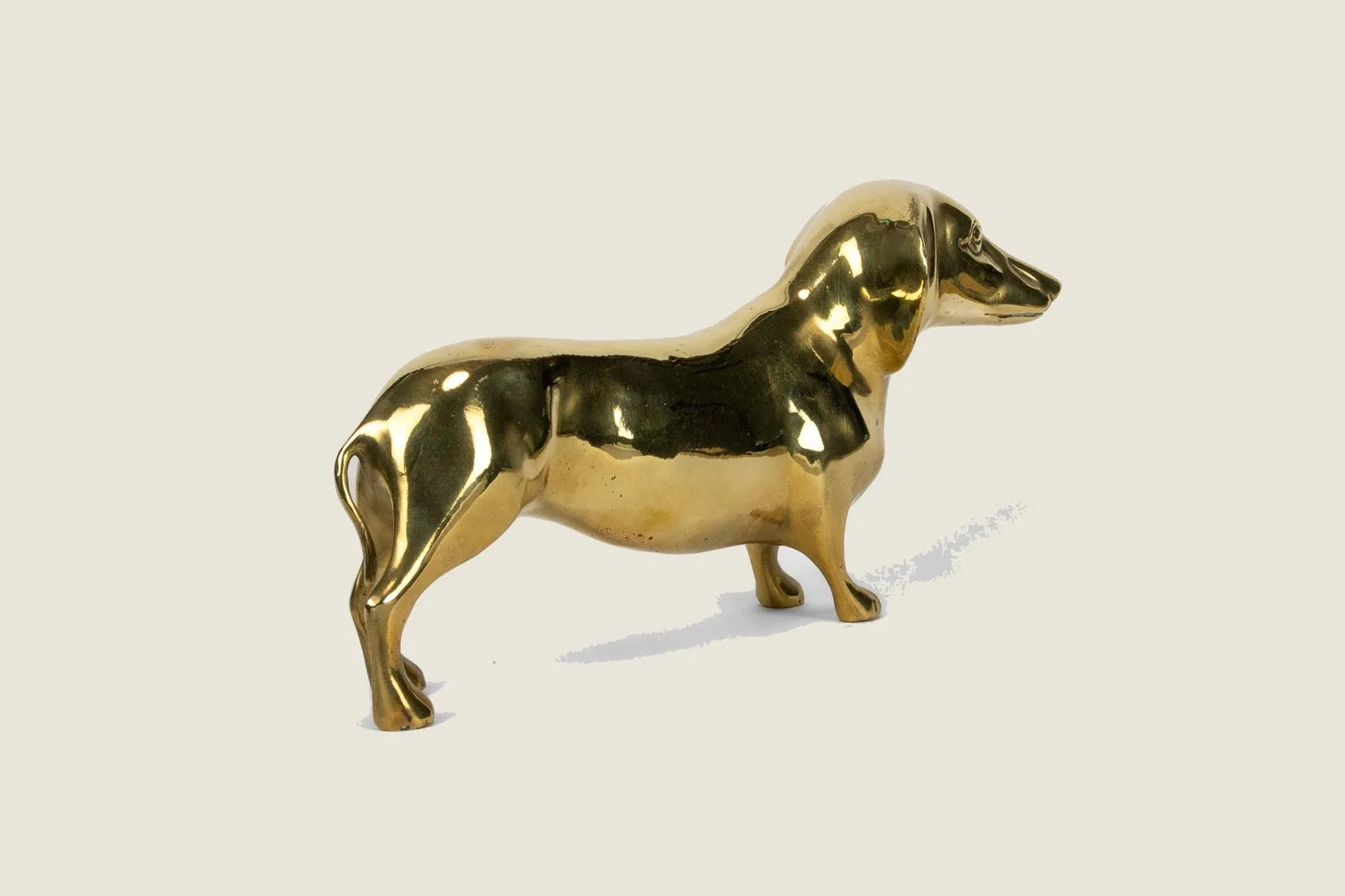 Handcrafted brass dachshund sculpture with a high gloss finish, measuring 10 inches long, 5.5 inches tall.