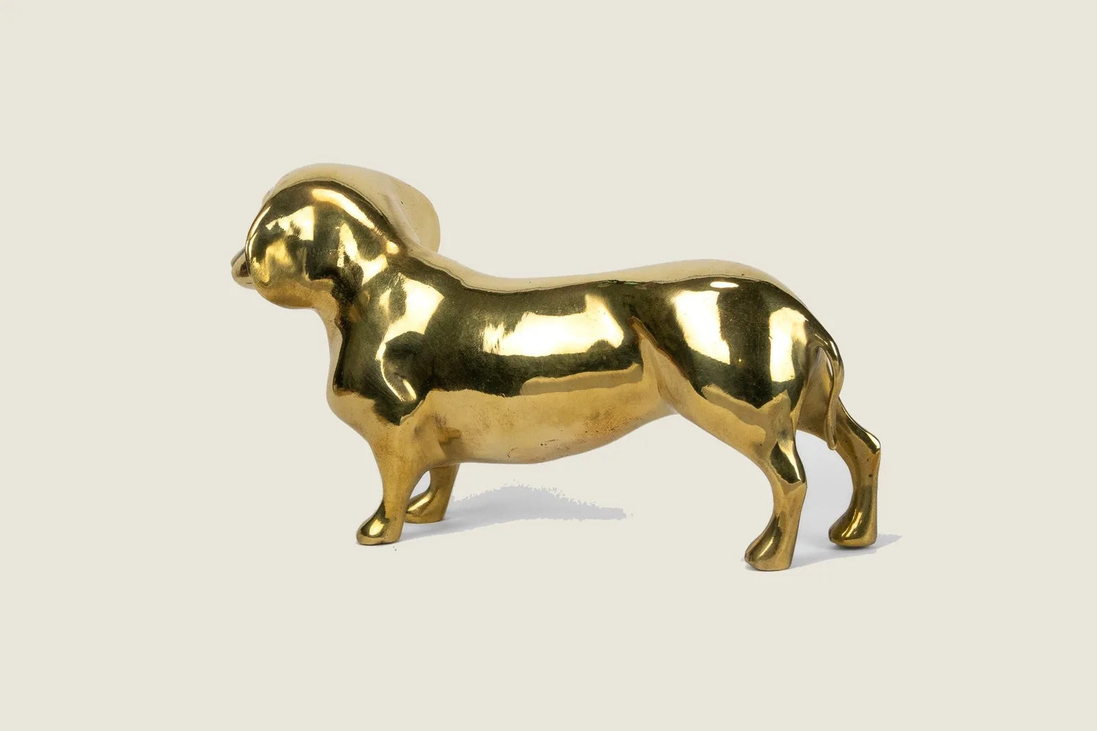 Handcrafted brass Dachshund sculpture with a high gloss finish, adding charm to any decor.