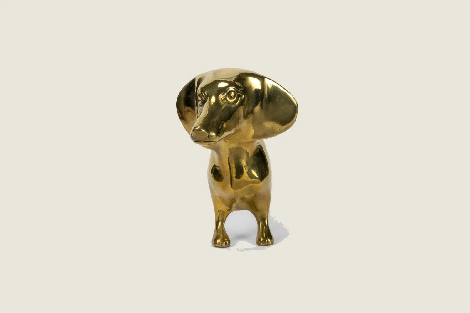 Handcrafted brass Dachshund sculpture with a polished high gloss finish, measuring 10 inches long and 5.5 inches high.