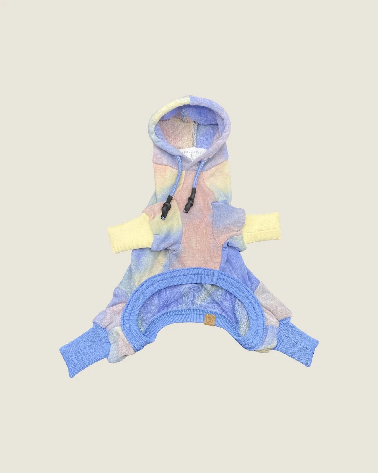 Rainbow tie-dye hooded onesie in soft cotton blend, featuring yellow and blue ribbed cuffs and a drawcord hood.