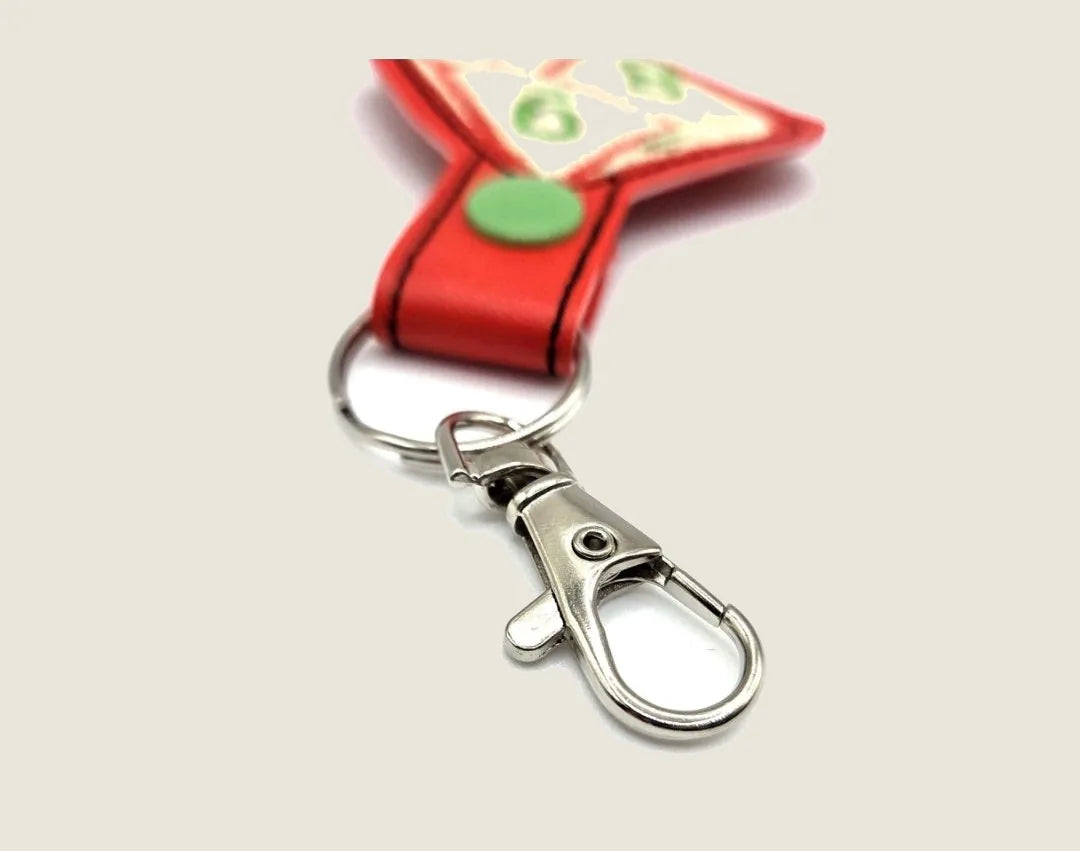 Red keychain strap featuring a silver lobster claw clasp and circular green button. Ideal for TTRPG enthusiasts.