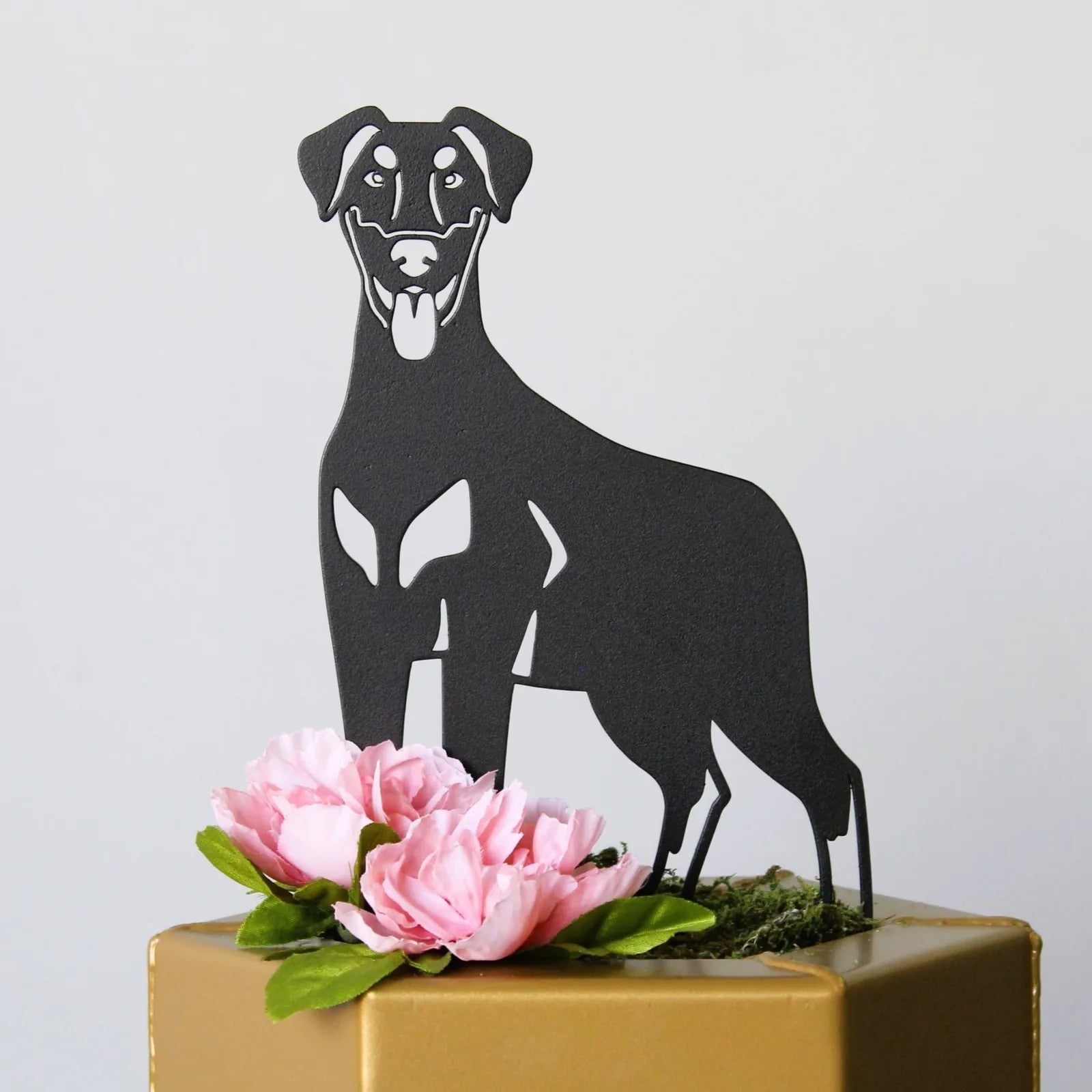 Black Doberman Pinscher metal silhouette with a sleek design, adorned with pink flowers and green leaves on a gold base.