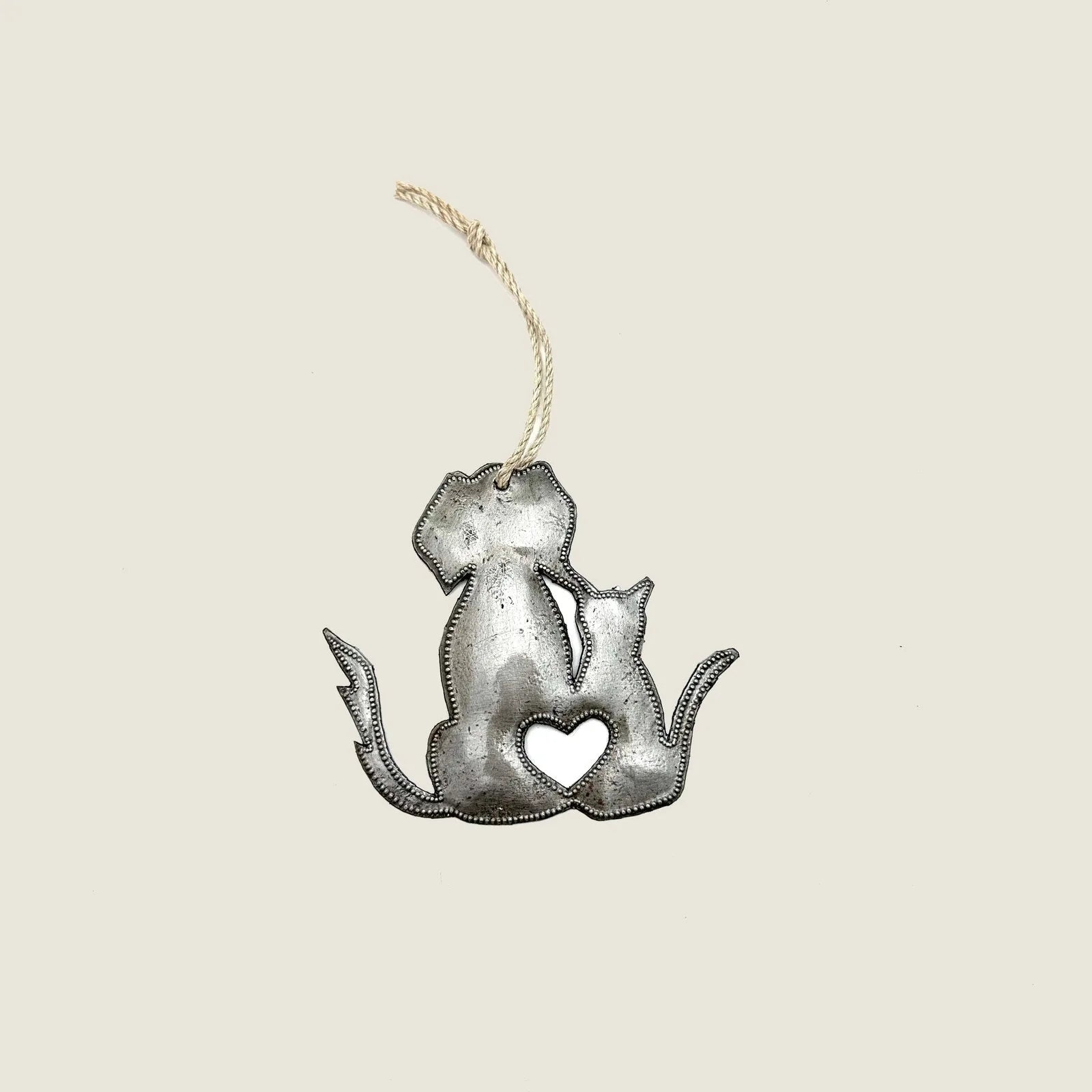 Handcrafted ornament featuring a dog and cat silhouette with a heart cutout, made from recycled steel.