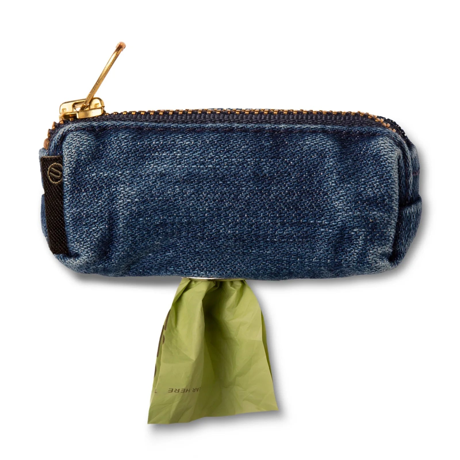 Compact raw denim dog bag holder with a brass zipper, featuring a green poop bag partially extended.