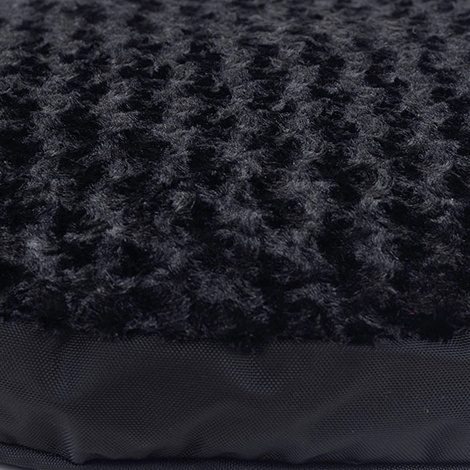 Soft black Minky Rose Fleece on top of an orthopedic dog bed, featuring a durable nylon bottom and plush texture.