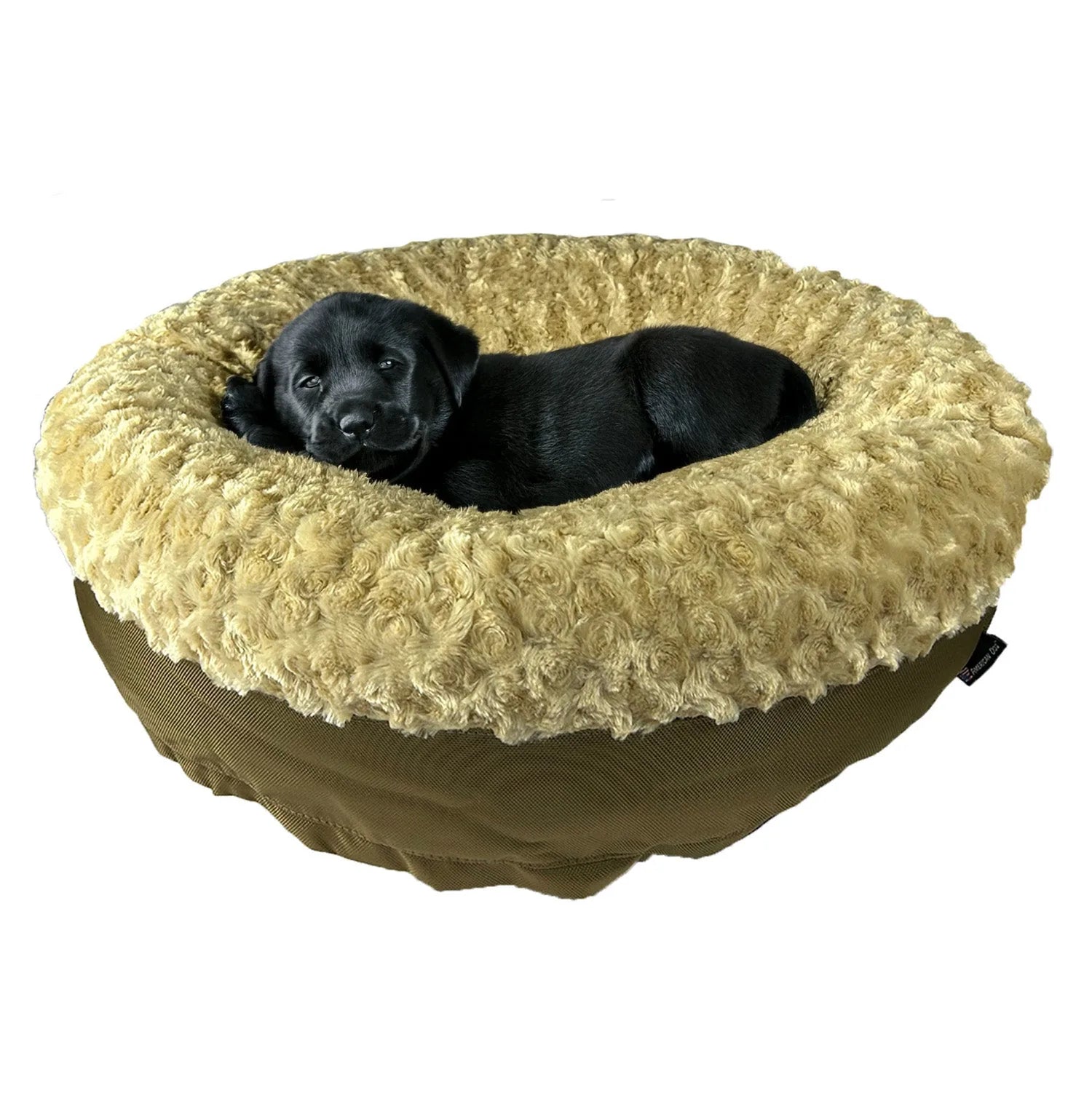 Black puppy resting in a round bolstered dog bed with a soft, beige fleece top and sturdy brown nylon bottom.