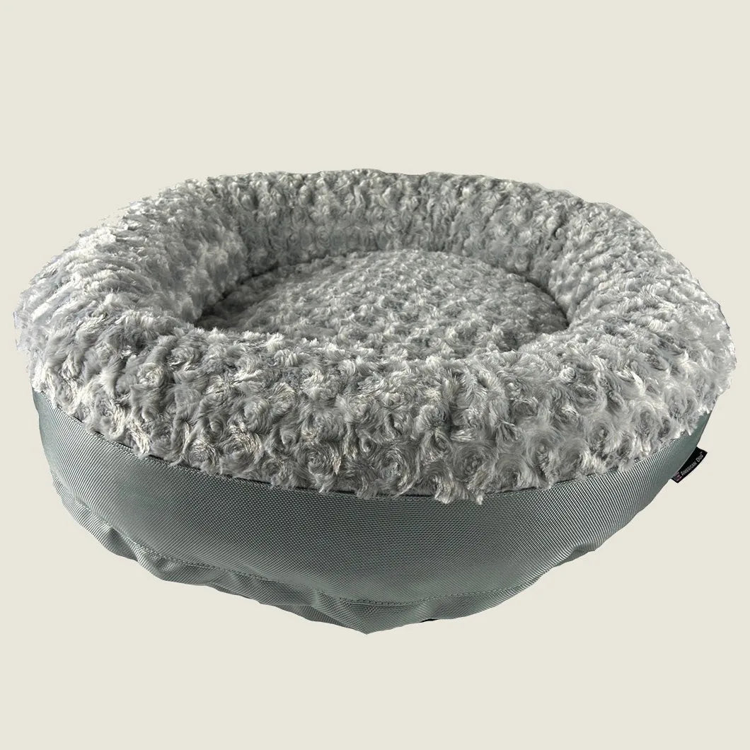 Round bolstered dog bed in soft gray furvana™ fleece, featuring a sturdy green nylon base and cozy nesting design.