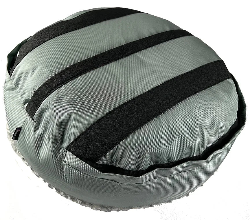 Round bolstered dog bed in gray fabric with black straps, providing comfort and support for pets.