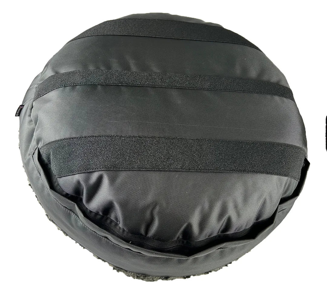 Round black dog bed featuring durable ballistic nylon material and soft Minky Rose Fleece for comfort.