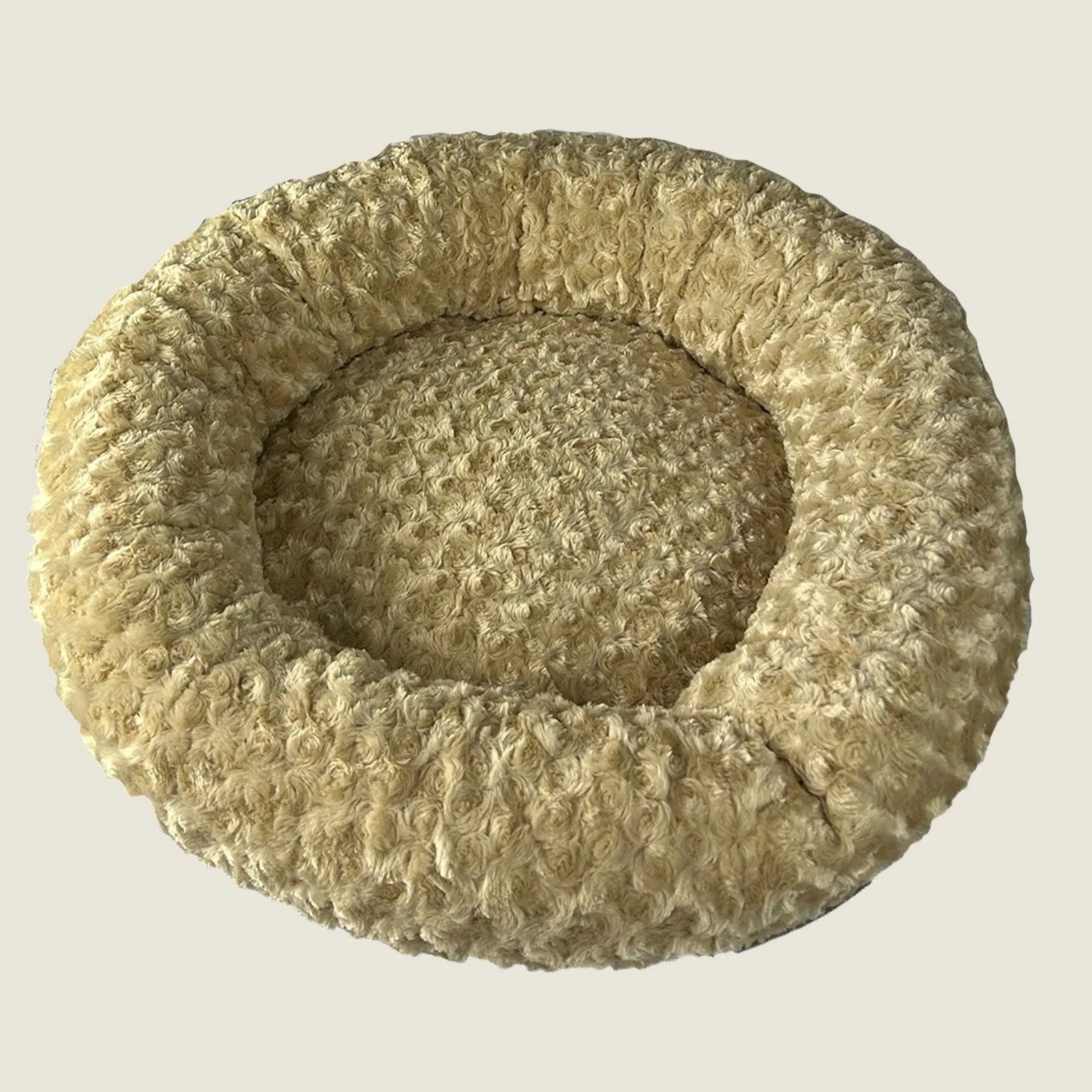 Round bolstered dog bed in soft camel Minky Rose Fleece, featuring a cozy nest-like design for comfort and security.