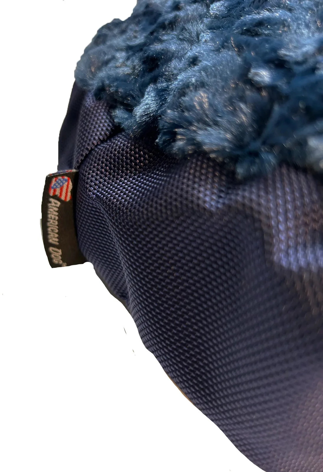 Close-up of the Round Furvana Dog Bed in dark navy, featuring a soft fleece top and durable ballistic nylon bottom.